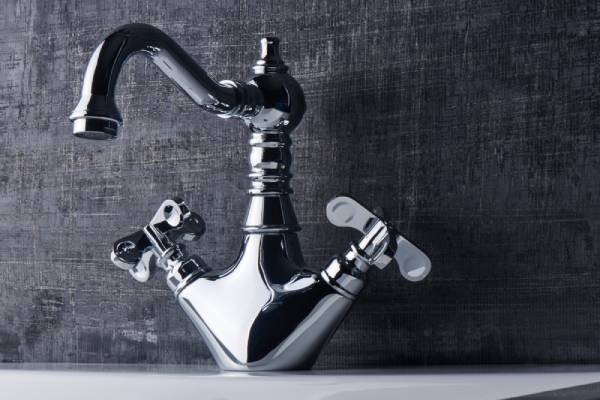 A classic chrome double-handle faucet, demonstrating the traditional design and separate hot/cold controls. 